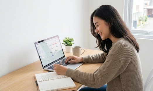 Mahasiswa produktif mengatur jadwal kuliah dan magang menggunakan laptop serta planner.